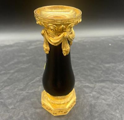 un vase noir et doré orné d'un motif doré