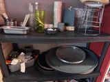 a black shelf with pots and pans on top of it