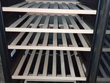 a black oven with wooden shelves inside of it