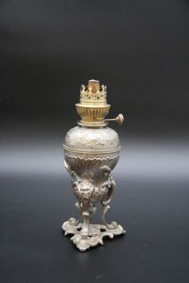 un vase en argent avec un couvercle en or posé sur une table noire