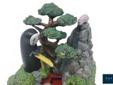 a figurine of a man holding a surfboard in front of a tree