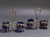 three silver and blue glass cups and spoons sitting on a table