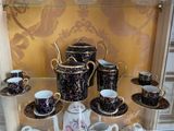 many cups and saucers on display in a glass case