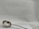a silver spoon sitting on top of a piece of paper next to a cup