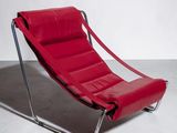 un fauteuil en cuir rouge posé sur un sol blanc