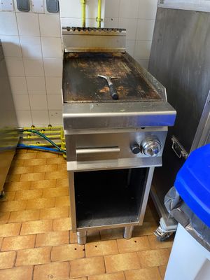 une image d'une cuisine avec une cuisinière et une poubelle
