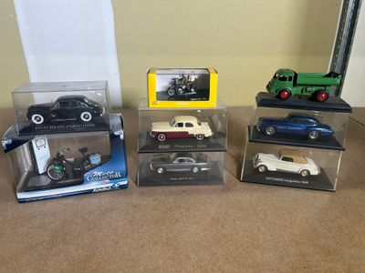four different models of cars in boxes on a table