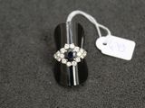 an image of a ring with a blue stone surrounded by white diamonds
