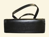black leather purse with handle and strap on a white background
