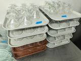 several trays with empty glasses on them on a table
