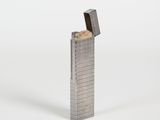 briquet en métal argenté sur fond blanc, avec un briquet au centre