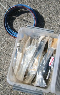 un récipient en plastique posé par terre et rempli de divers objets