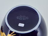 a black vase with a gold design on it