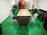 une table et des chaises dans une pièce où l'on peut voir une fresque représentant un ballon de basket sur le mur