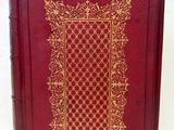 un vieux livre rouge avec une bordure dorée sur la couverture