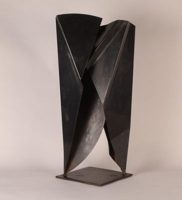 une sculpture en métal noir posée sur une surface blanche, avec un fond blanc