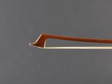 a close up of a violin bow on a gray background