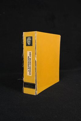 an old yellow book sitting on top of a black table