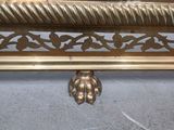 gold metal shelf with a decorative design on the top of it