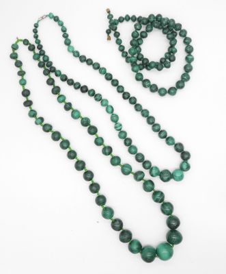 un gros plan sur un collier de perles vertes et une paire de boucles d'oreilles