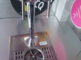 un robinet à bière posé sur une table en métal, devant une enseigne
