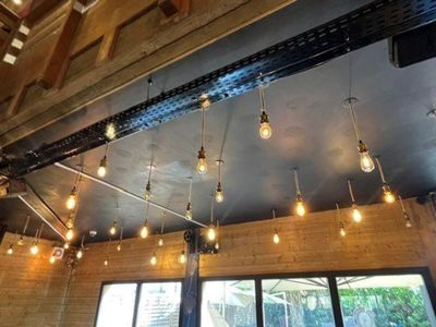 many light bulbs hanging from the ceiling of a restaurant