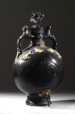 un vase noir orné d'un motif doré sur le dessus