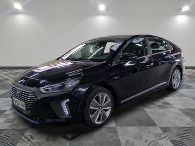 la voiture noire est garée sur un sol en damier dans le garage