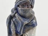 a figurine of a person wearing a scarf and a hat