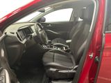 the interior of a red car with the door open and the passenger seat down