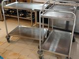 two stainless steel trolleys in a kitchen with a stove in the background
