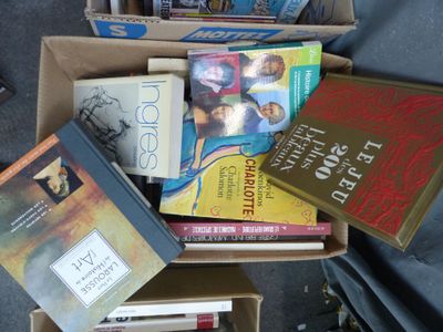 de nombreux livres dans une boîte posée par terre