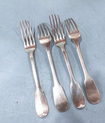 four forks and a knife are sitting on a blue surface