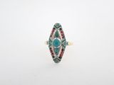 un gros plan d'une bague ornée d'une turquoise entourée de pierres multicolores