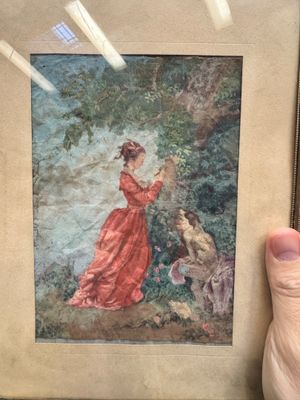 quelqu'un tient une photo d'une femme en robe rouge