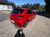 the rear end of a red car parked on the side of the road