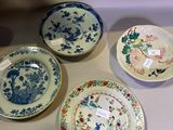 four plates on display on a table with tags on them