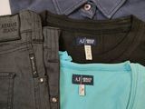 three pairs of men ' s jeans are stacked on top of each other
