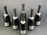 six bottles of champagne are lined up in a row