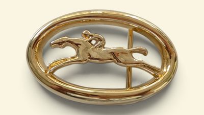 a gold brooch with a horse and rider on it
