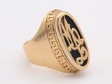 a close up of a gold ring with a monogram on it