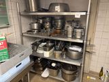 de nombreuses casseroles et poêles sur les étagères de la cuisine