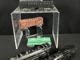 trois petits trains posés sur une boîte transparente