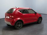 the rear end of a red car is parked in a room