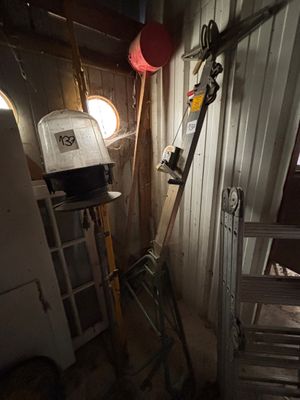 une pièce dans laquelle se trouvent une échelle, une fenêtre et une lampe