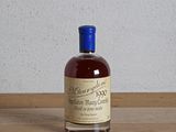 une bouteille d'alcool posée sur une table à côté d'une bouteille de vin