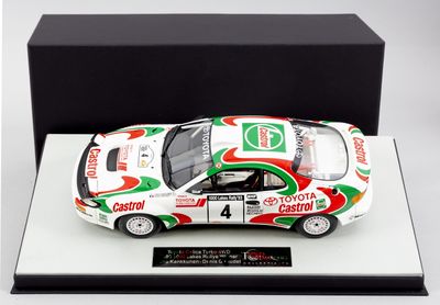 une maquette de voiture blanche avec des touches de peinture verte et rouge