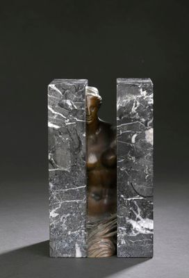 une statue représentant une femme debout entre deux blocs de marbre