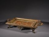an antique brass tray with handles and handles on a gray surface