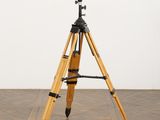 an image of a tripod on a wooden floor with a white wall in the background